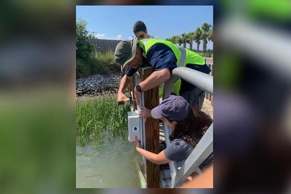 Students Kutub Ghandi and Maddie Carlini help Georgia Tech research scientist Russell Clark install a water level sensor at Turner Creek Boat Ramp on Whitemarsh Island